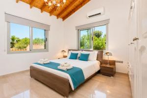 a bedroom with a large bed and windows at Villa Stone House in Neo Chorio +13 photos