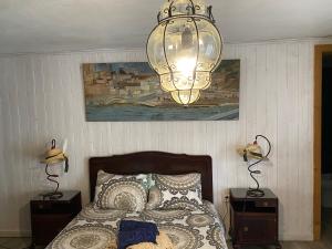 a bedroom with a bed and a chandelier at Casa S. Nicolau in Cabeceiras de Basto