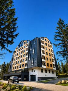 a large building with a black roof at Trebevic Skyline Apartman in Dovlići