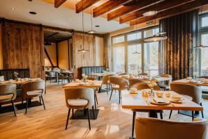 a restaurant with wooden floors and tables and chairs at WALDGUT Naturresort in Bad Gottleuba