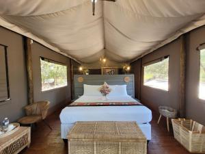 a bedroom with a bed in a tent at Rustic Gate Lodge and Campsite in Maun