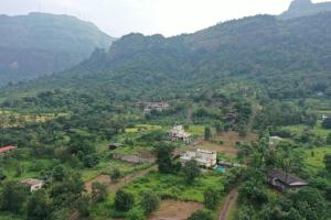 an aerial view of a village in a mountain valley at Shri Bhuvaneshvari Homestay in Karjat