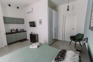 a bedroom with a green bed and a kitchen at La maison de tante Rosa in Syracuse