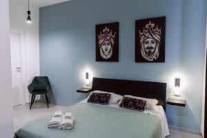a bedroom with a bed with two slippers on it at La maison de tante Rosa in Syracuse
