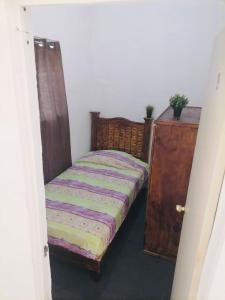 a bedroom with a bed and a wooden dresser at Hostal Queretaro LOMAS M in Laborcillas