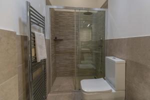 a bathroom with a toilet and a glass shower at La maison de tante Rosa in Syracuse +62 photos