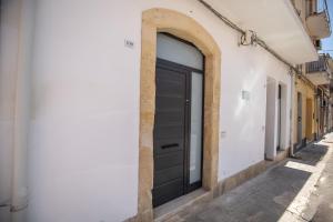 a black door on the side of a building at La maison de tante Rosa in Syracuse