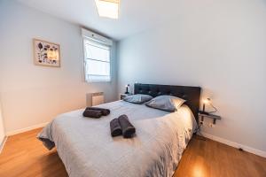 a bedroom with a large bed with two bags on it at Terrasse de l'aber Roscoff in Roscoff