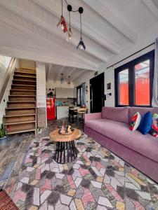 a living room with a purple couch and a table at Casa de Madera in Pavliani