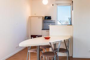 a kitchen with a white table and chairs at Terrasse de l'aber Roscoff in Roscoff