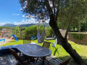 a table and chairs and a hammock in a yard at Casa S. Nicolau in Cabeceiras de Basto
