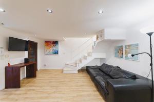 a living room with a black leather couch and stairs at Best view Giovinazzo in Giovinazzo