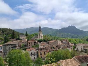 a view of a town with a church in the distance at maison MON REVE in Le Vigan