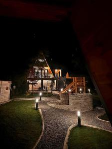 Nachtansicht eines Hauses mit Lichtern im Gras in der Unterkunft Fox Cabins in Trăisteni + 87 Fotos