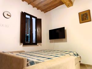 a bedroom with a bed and a flat screen tv at Roveto Home in Siena