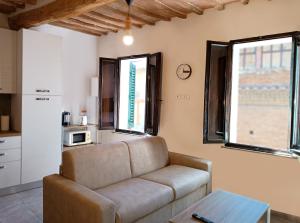 a living room with a couch and two windows at Roveto Home in Siena +3 photos