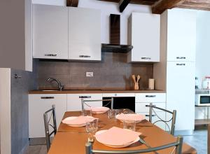 a kitchen with a table with chairs and white cabinets at Roveto Home in Siena