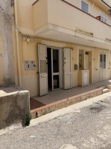 a building with doors and windows on a sidewalk at Blue Home in Lampedusa