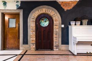 a wooden door with a window on a wall at Hagios House in Pretoria
