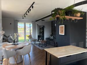 a kitchen and living room with a table and chairs at Żuławski Chillout in Stanisławowo