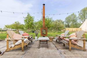 a patio with two chairs and a table with a fire pit at Tipi Marie at Logie Marie in Kaprijke