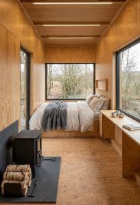 una camera da letto con un letto, una scrivania e finestre di Stuga a Érezée