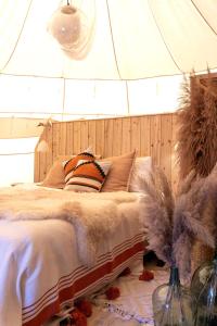 a bedroom with a bed with a wooden head board at Tipi Marie at Logie Marie in Kaprijke