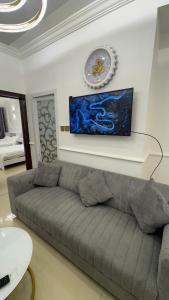 a living room with a couch and a clock on the wall at كورنيش عجمان in Ajman 