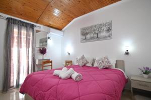 a bedroom with a pink bed with towels on it at Villa Evelin in Asprovalta +57 photos