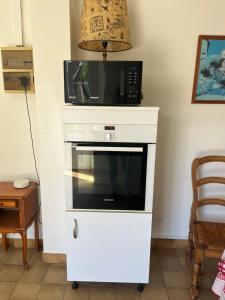a microwave on top of a white dresser at Le Petit Clos périgourdin in Église-Neuve-de-Vergt