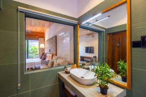 a bathroom with a sink and a large mirror at Cascara Resort Weligama - A Tropical Sanctuary in Weligama