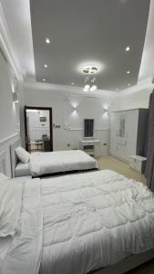 a large white bedroom with two beds in it at كورنيش عجمان in Ajman 