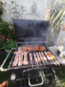 a grill with meat and hamburgers on it at Villa Evelin in Asprovalta