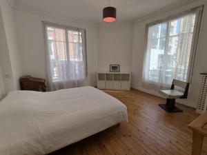 a white bedroom with a bed and windows and a desk at LE GATSBY, appartement ART DECO 4 pers, plage et hyper centre in Le Havre