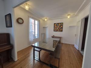 a living room with a table and a clock on the wall at LE GATSBY, appartement ART DECO 4 pers, plage et hyper centre in Le Havre