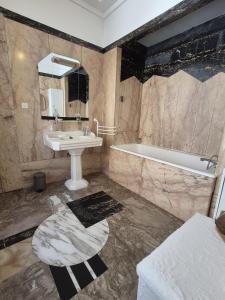 a bathroom with a sink and a bath tub at LE GATSBY, appartement ART DECO 4 pers, plage et hyper centre in Le Havre +40 photos