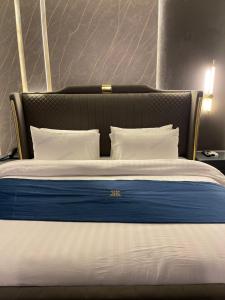 a bed with a blue and white blanket and pillows at Grand Blu Hotel in Hyderabad