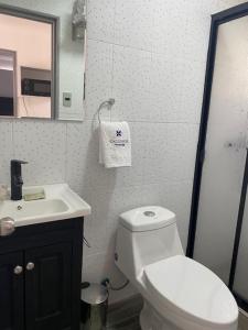 a bathroom with a white toilet and a sink at Refugio Callihue in El Ajial