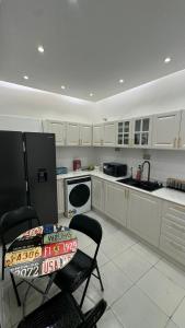 a kitchen with white cabinets and a black refrigerator at كورنيش عجمان in Ajman 
