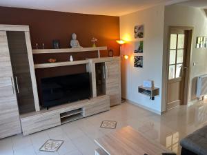 a living room with a large entertainment center with a television at Ferienhaus Lechseeidylle in Lechbruck