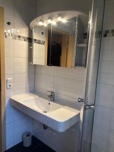 a white bathroom with a sink and a mirror at Ferienhaus Lechseeidylle in Lechbruck +19 photos