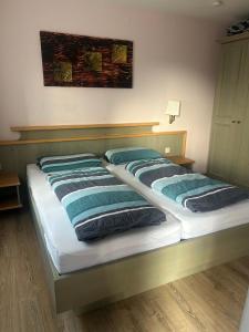 two beds with pillows on them in a bedroom at Ferienhaus Lechseeidylle in Lechbruck