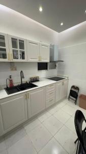 a kitchen with white cabinets and a sink at كورنيش عجمان in Ajman  +7 photos