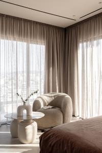 a bedroom with a bed and a chair and a table at MonCasa suites in Agios Nikolaos
