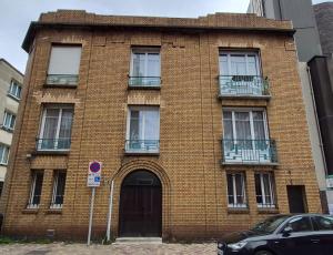 a red brick building with a door and a balcony at LE GATSBY, appartement ART DECO 4 pers, plage et hyper centre in Le Havre