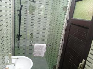 a bathroom with a sink and a glass shower at Lovely surulere apartment in Lagos