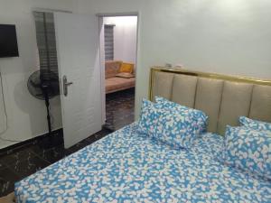 a bedroom with a bed with blue sheets and pillows at Lovely surulere apartment in Lagos