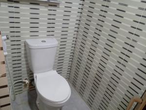 a bathroom with a white toilet in a stall at Lovely surulere apartment in Lagos