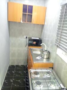 a small kitchen with a stove and a pot on it at Lovely surulere apartment in Lagos