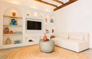 a living room with a white couch and a tv at Casa Sol in Denia